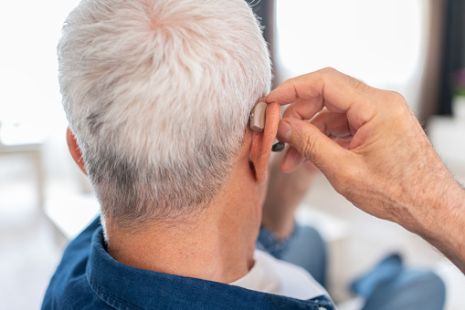 Senior Man Inserting His Hearing Aid