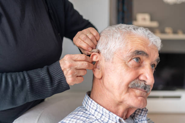 istock Caregiver Helping Senior Man With Hearing Aid 1499161727