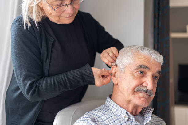 istock Senior Woman Helping Her Husband With Hearing Aid 1499161825