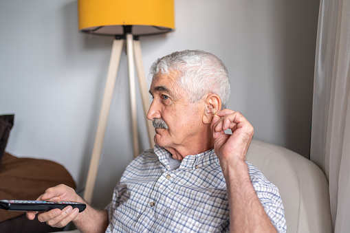 Senior Man With Hearing Aid Watching Television