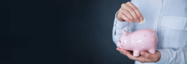 istock hand piggy bank with coin 1499168244