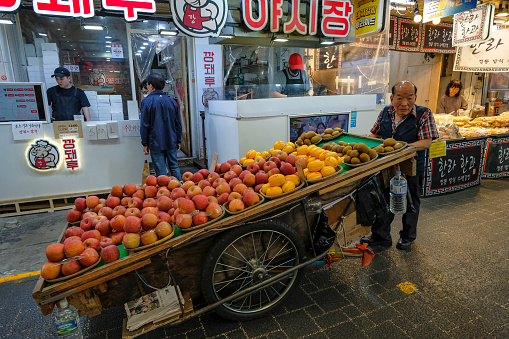 Busan, South Korea - May 26, 2023: A fruit seller in the Gukje Market or International market located in nampodong district in Busan, South Korea.