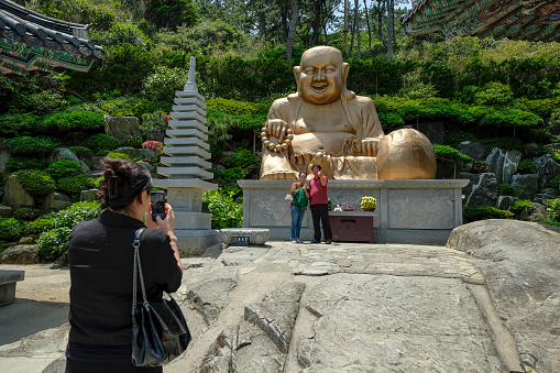Busan, South Korea - May 27, 2023: Tourists taking photos in the Haedong Yonggungsa Temple, it is one of the rare Korean temples situated on the seaside, Busan, South Korea.