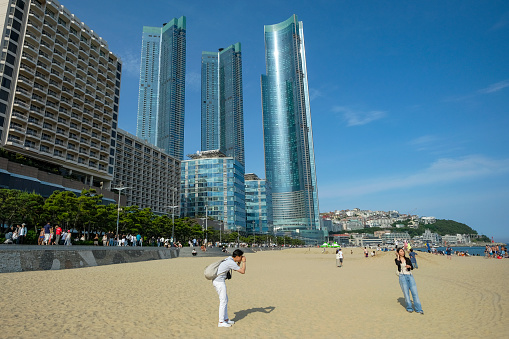 Busan, South Korea - May 27, 2023: People walking along the Haeundae Beach in Busan, South Korea.