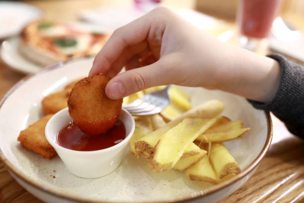 istock Person dipping nuggets in ketchup 1499174082