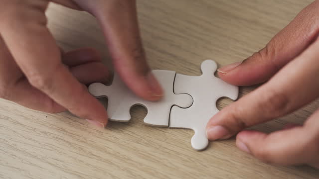 Woman hands connect two pieces of jigsaw puzzle. teamwork, business organization and planning , love, couple concept