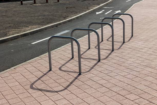 istock Bicycle parking stand situated next to a paved footpath bordering a road. 1499184094