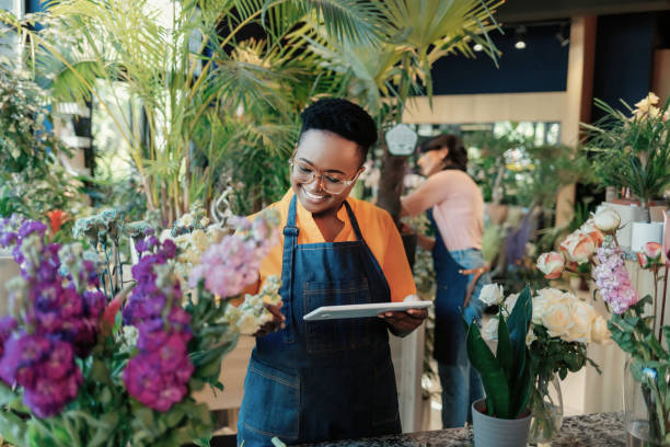 black flower shop owner with digital tablet - garden center flower women plant imagens e fotografias de stock