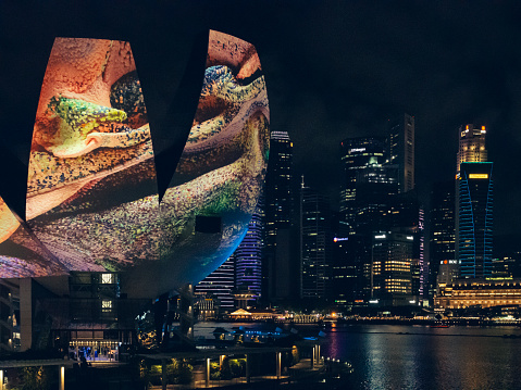 Singapore - June 16 2023: Night view of the Singapore ArtScience Museum. The projection on its facade is an art installation titled Glacier Dreams, which is part of the 
