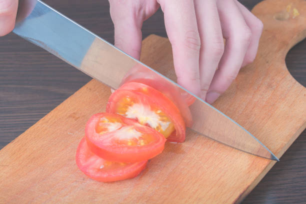 istock slicing a tomato with a knife on a board 1499194415