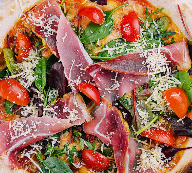 istock Pizza with prosciutto meat on wooden board 1499194709