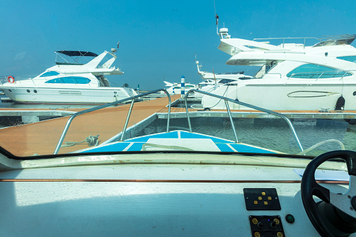 Steering wheel and control panel on luxury motorboat, background with copy space, full frame horizontal composition