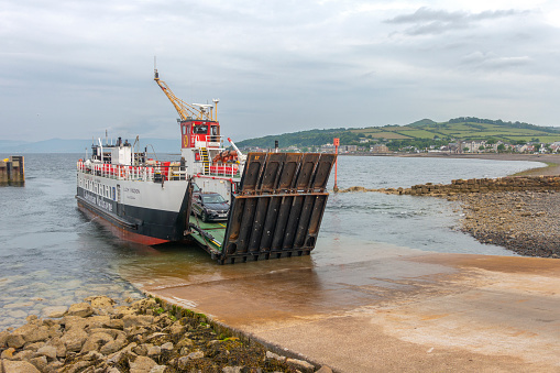11th June 2023 - Largs, Scotland, UK: MV Loch Riddon, a small ro-ro ferry operated by CalMac, lowering its ramp to allow cars from the Isle of Cumbrae to drive onto the slip at Largs Pier. The ship was built in 1986 and is currently used as a second ferry on the Largs-Isle of Cumbrae route in summer months.