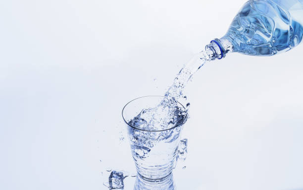 istock Pour water or clean water from a plastic or PET bottle into a drinking glass with ice cubes. Cold drinking water to quench thirst and refresh. 3D rendering 1499198900