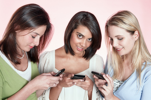 Group of young women using their mobile phones.