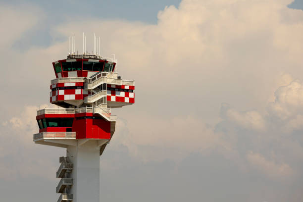 Airport tower with a blue sky in the background. The building has a unique shape and he is a tower. Airport control tower stood tall, overseeing the bustling activity on the runways below