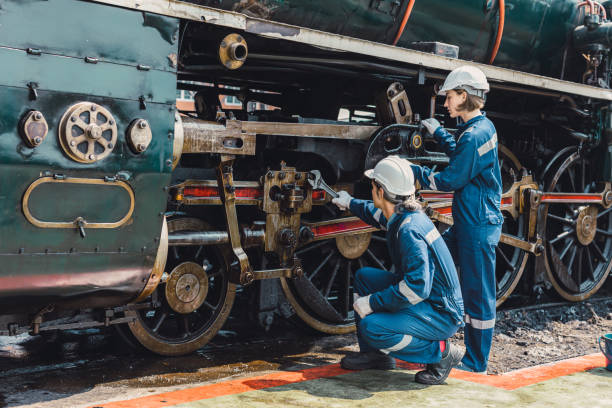 istock Train engineer team working service maintenance old dirty vintage classic steam engine locomotive in train repair workshop at train station. 1499212771