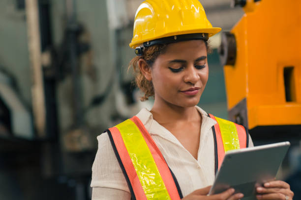 istock Happy African American Woman Engineer Worker Supervisor looking at Tablet computer to control operate maching in Heavy Industry Factory. 1499212852