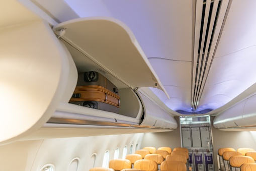 In flight carry on bag cabinet, on board suitcase storage overhead bin in passenger cabin crew.