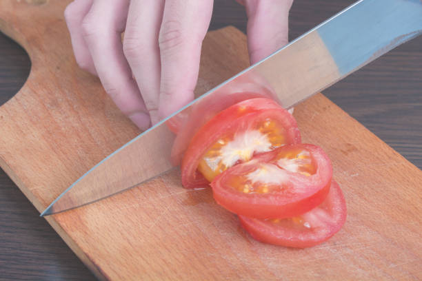 istock slicing a tomato with a knife on a board 1499214438