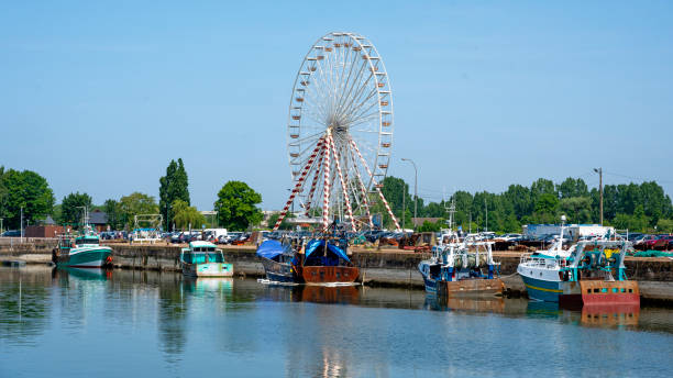 fishing boats and giant wheel fishing boats and giant wheel at the harbour of the village Honfleur in the Normandy on occasion of the marines day at pentecost, France whitsun stock pictures, royalty-free photos & images