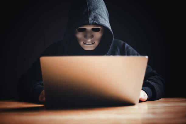 istock Black hat hacker in hood using tablet on desk to hacking privacy sensitive data cyber crime hack in dark room background matrix binary code. Cyber security cyber crime concept. Hacking phishing 1499218687