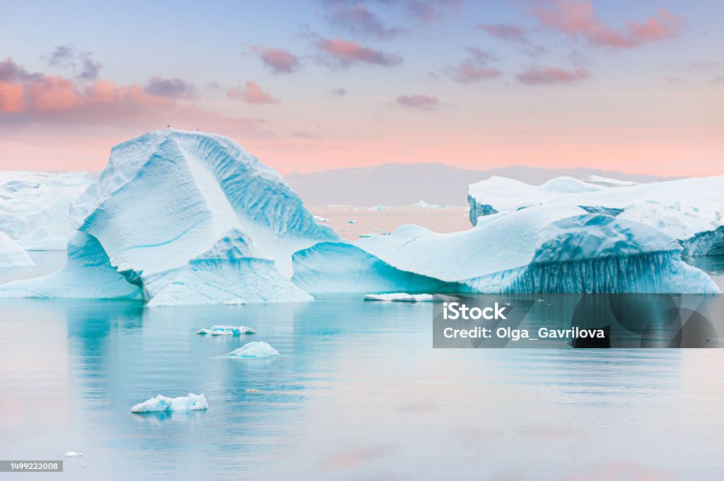 Icebergs in Atlantic ocean at sunset. Ilulissat icefjord, western Greenland.. Icebergs in Atlantic ocean at sunset. Ilulissat icefjord, western Greenland.. Blue ocean and the pink sky with clouds. Summer seascape Ilulissat Stock Photo
