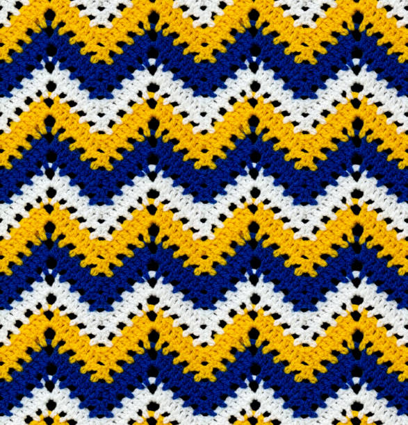 Seamless knitted pattern in the form of openwork zigzags crocheted with threads of contrasting colors. Acrylic baby yarn. African style.