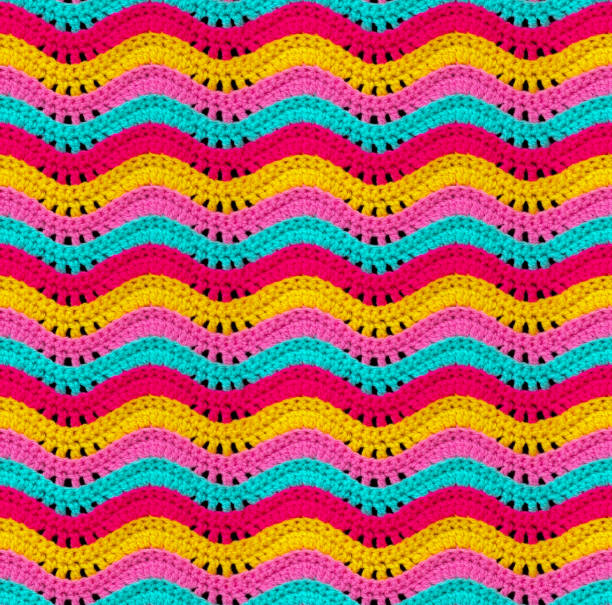 Seamless knitted pattern in the form of openwork waves is crocheted with threads of bright colors. Acrylic baby yarn.