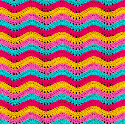 Seamless knitted pattern in the form of openwork waves is crocheted with threads of bright colors. Acrylic baby yarn. Volumetric style.