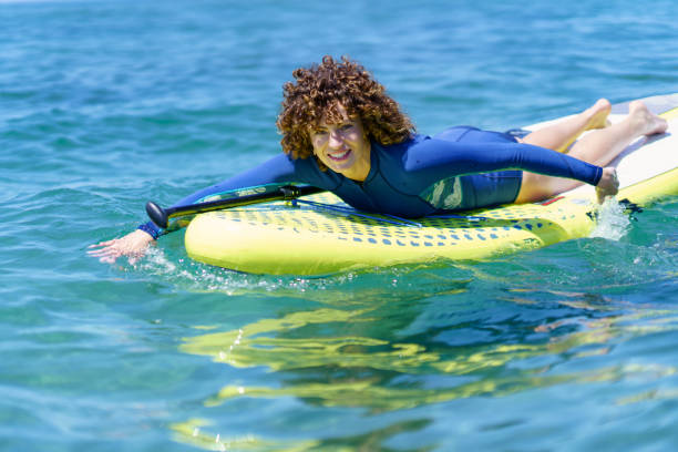 istock Smiling lady on SUP board in water 1499222912