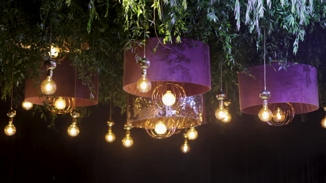 Modern chandeliers with rustic lightbulbs. Ballroom decoration. Event Decoration.