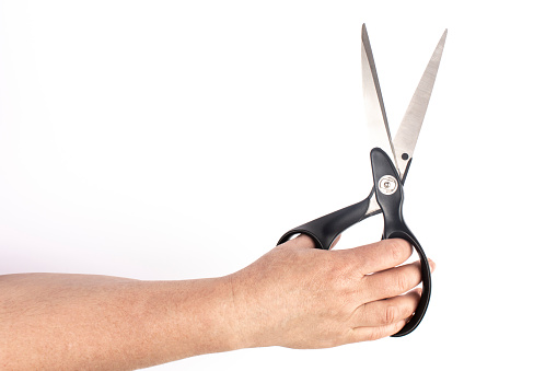 hand with black scissors in white background isolate