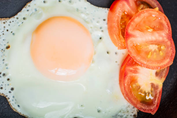 istock fried egg with tomatoes in a cast-iron frying pan on a wooden table 1499225659