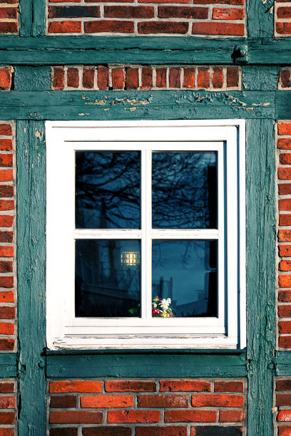 Window on the wall of an old half-timbered house stock photo