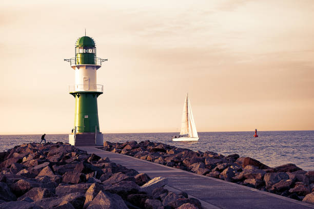 Green lighthouse on the coast of the Baltic Sea in sunset stock photo