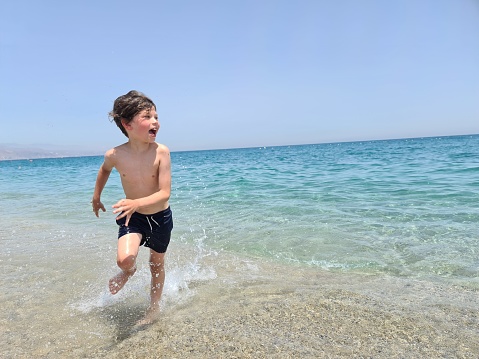 Happy boy running at the beach