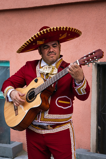Mexican musician mariachi plays the guitar on a city street