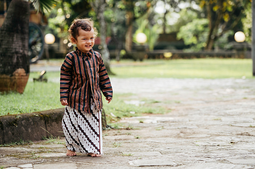 young kid using surjan (Yogyakarta tradition dress) playing at the joglo house