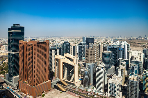 Cityscape district Dubai modern skyscrapers sunny summer day, urban background. Panoramic aerial view of UAE city housing new towers. Construction and modern architecture concept. Copy ad text space