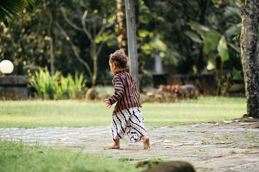 young kid using surjan (Yogyakarta tradition dress) playing at the joglo house