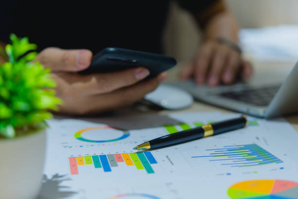 istock Businessperson hand holding pen documents chart analysis diagram and graph statistic report investment and financial information on desk. 1499234906