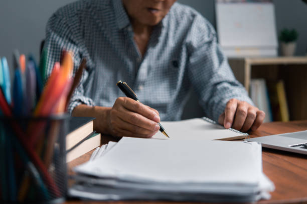 istock Asian senior businessman taking notes on business report 1499235133