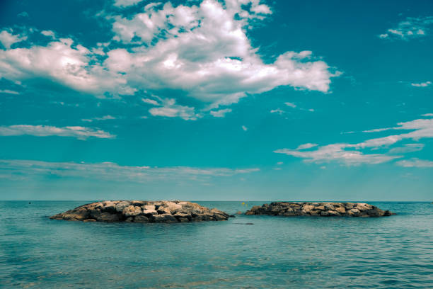 Two stone formation islands on the turquoise water of the mediterranean sea in Barcelona, Sitges