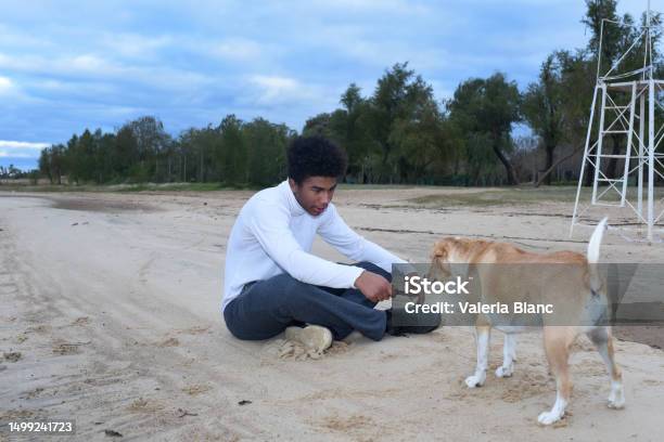 Young Man With Beagle On The River Bank Stock Photo - Download Image Now - 20-24 Years, Adult, Adults Only