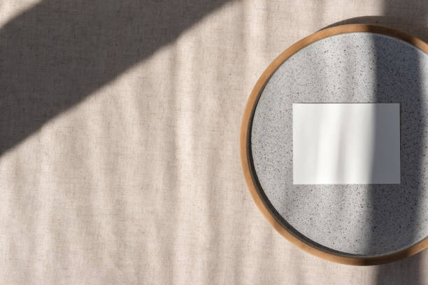 istock Blank paper card mockup on gray ceramic plate on neutral beige linen tablecloth with geometric sun light shadows, aesthetic business brand, wedding invitation template 1499245804