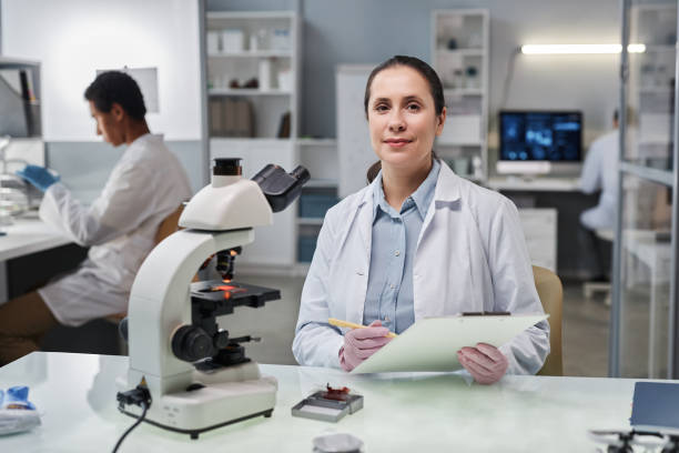 istock Woman scientist looking at camera working with microscope in laboratory 1499247614