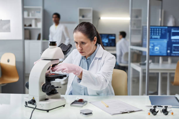 istock Woman scientist putting test material in microscope in laboratory 1499247621