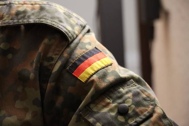 istock Green and brown camouflage jacket with a flag of Germany patch 1499249375