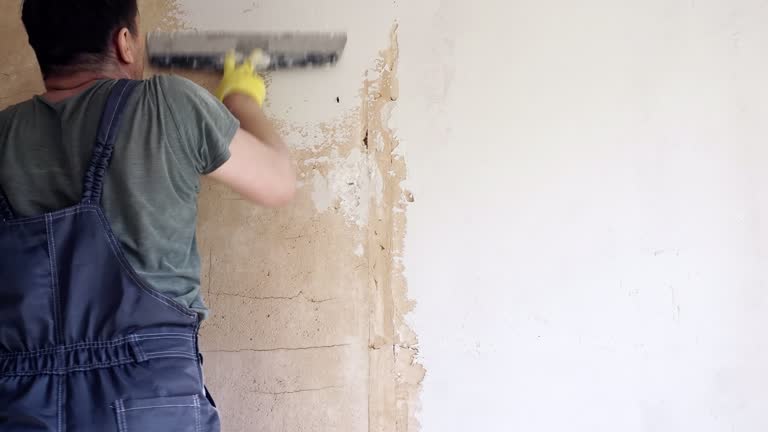 Worker applying putty to wall, time-lapse.